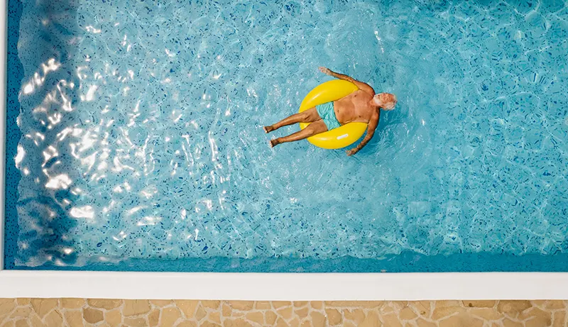 Older man floting in clean swimming pool